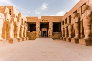 Giant avenue of sphinxes leading to the illuminated Luxor Temple at dusk