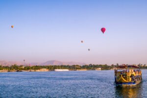 Luxor to Aswan Nile River Cruise ship sailing at sunset