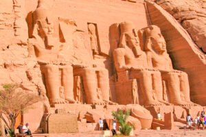Four colossal seated statues of King Ramses II carved into the sandstone facade at Abu Simbel.