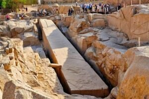 Tourists walking on wooden pathways around the Unfinished Obelisk in Aswan