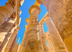 Towering carved stone columns inside the Great Hypostyle Hall at Karnak Temple in Luxor.