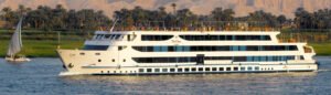 Nile cruise ship sailing past lush riverbanks and ancient sites in Egypt